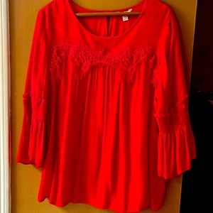 Ladies red blouse, with trim above the chest and 3/4in sleeves w/loose elastic.
